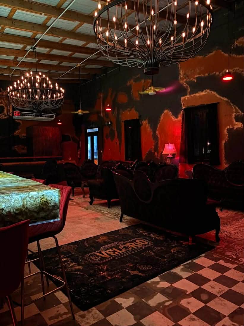 Sala con sofás de terciopelo, alfombra de El Velorio y piso de losetas