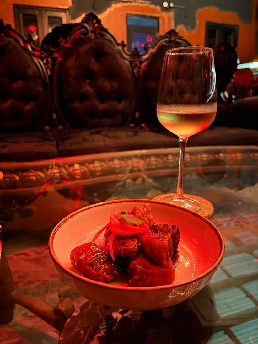Tapa de cerdo con cebolla encurtida y una copa de vino blanco